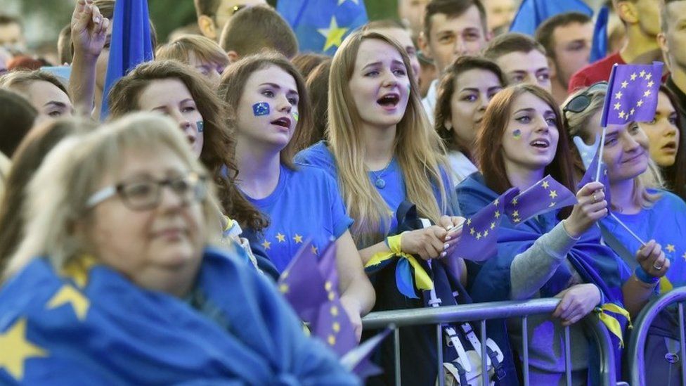 People wave European Union flags during a mass open-air concert on European Square in Kiev on June 10, 2017, dedicated to the abolition of EU visas for Ukrainian citizens