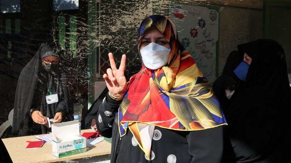 An Iranian woman gestures as she votes for presidential election at a polling station in Tehran