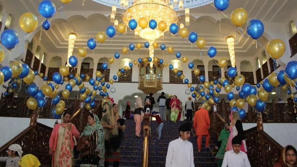 Blue and yellow balloons above a large set of stairs in Guru Nanak Darbar Gurdwara