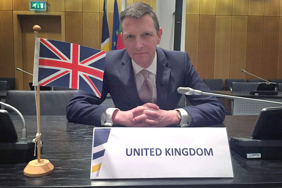 Mark Easton with UK flag in Europol boardroom
