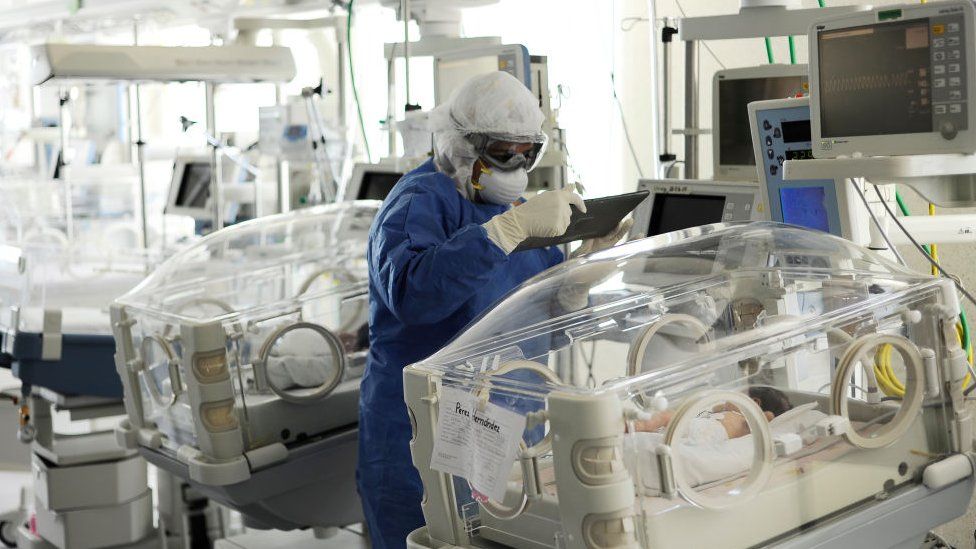 A nurse wears PPE while examines a baby attached to an incubator for in a hospital in Toluca, Mexico, on June 3, 2020
