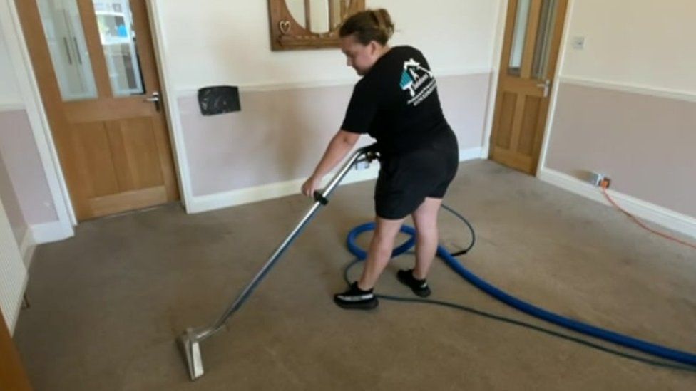 Abbie Austen cleaning a carpet
