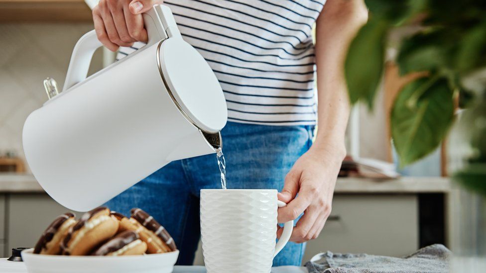 A woman boiling a kettle