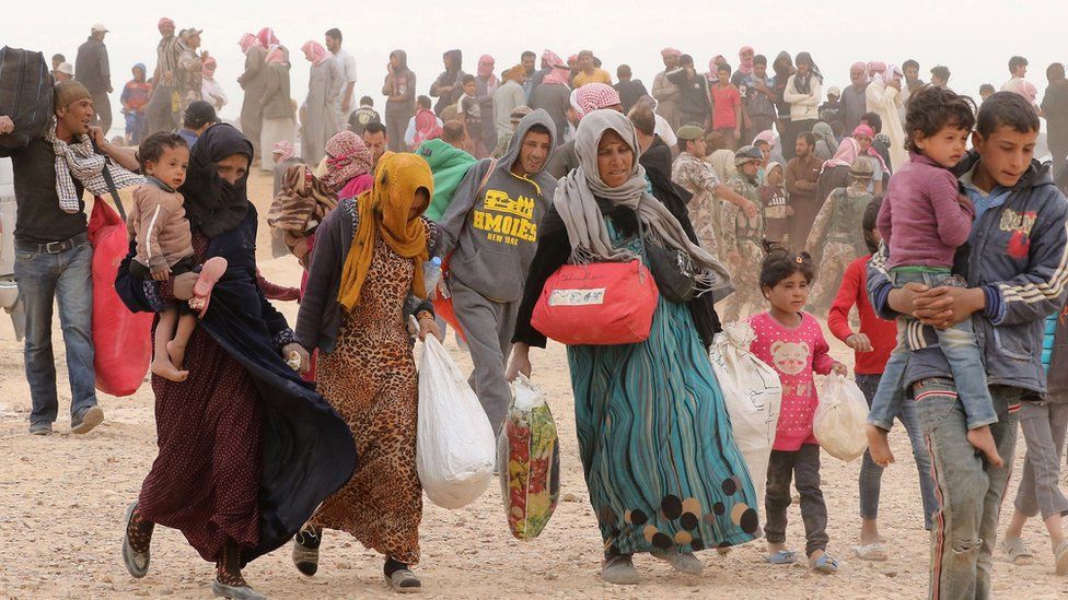 Syrian refugees wait to enter Jordan after fleeing the civil war