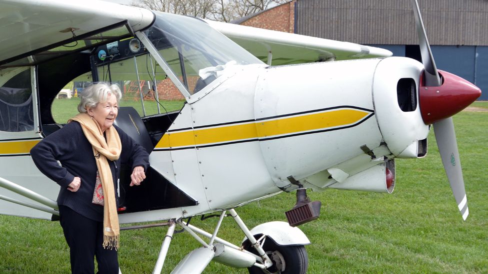 Mollie Anne Macartney stands next to a plane