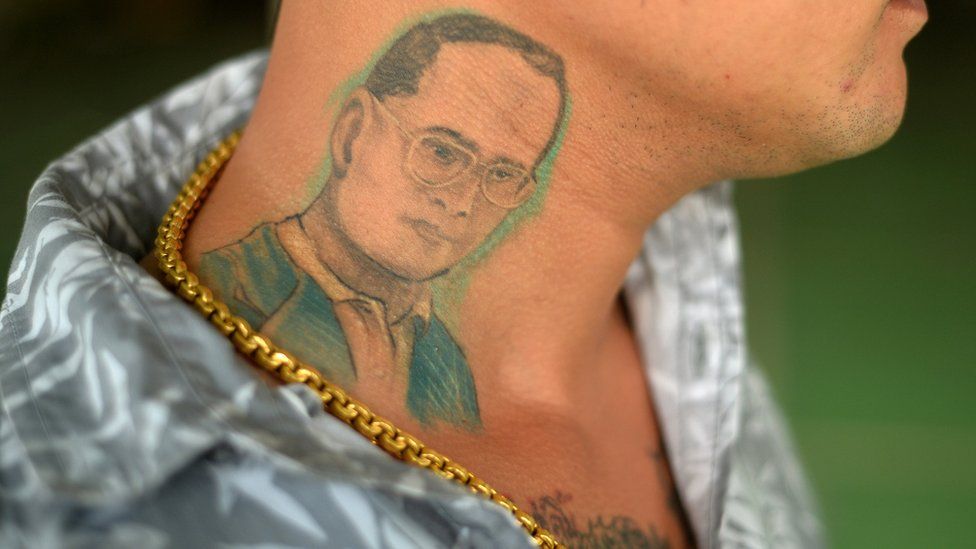A man poses for a photograph to show his tattoo of Thailand's King Bhumibol Adulyadej in Phuket, Thailand, June 7, 2016.
