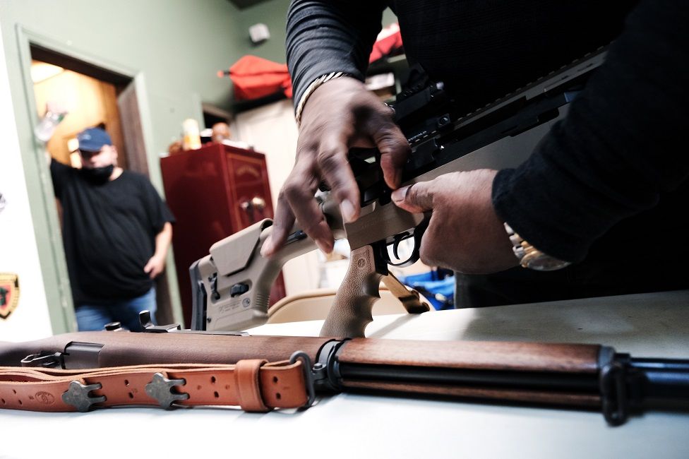 Lateif Dickerson handles some of his rifles at his gun instruction headquarters in New Jersey