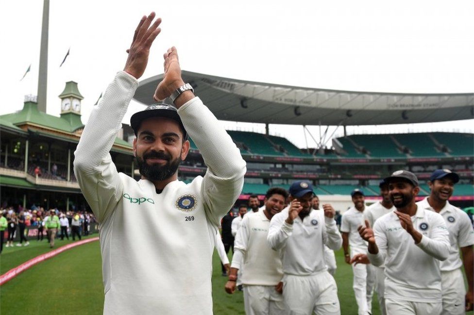 India"s captain Virat Kohli gestures to supporters as his teammates celebrate a 2-1 series victory over Australia following play being abandoned on day five in the fourth test match between Australia and India at the SCG in Sydney, Australia