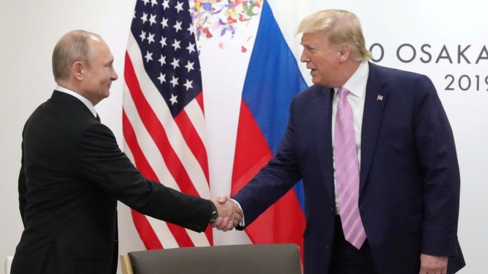 Russia's President Vladimir Putin shakes hands with US President Donald Trump