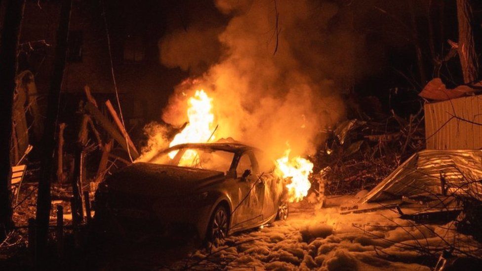 A view of a burning car following a Russian missile strike on a residential building in Kharkiv, on 30 December 2