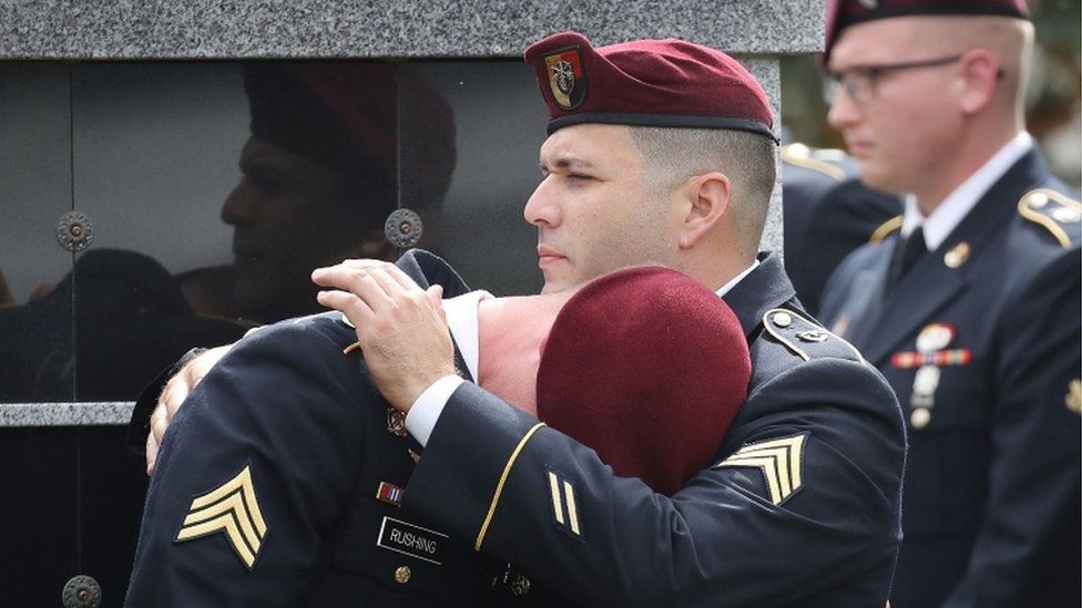 Members of Sgt La David Johnson's unit comfort each other as they attend the burial service for US Army sergeant in Hollywood, Florida, 21 October