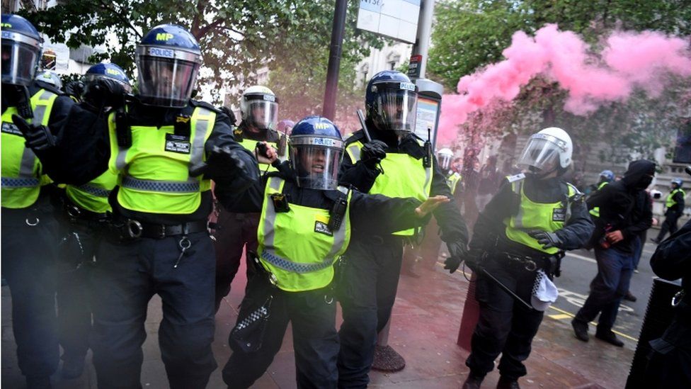 Police in riot gear clashed briefly with crowds in London