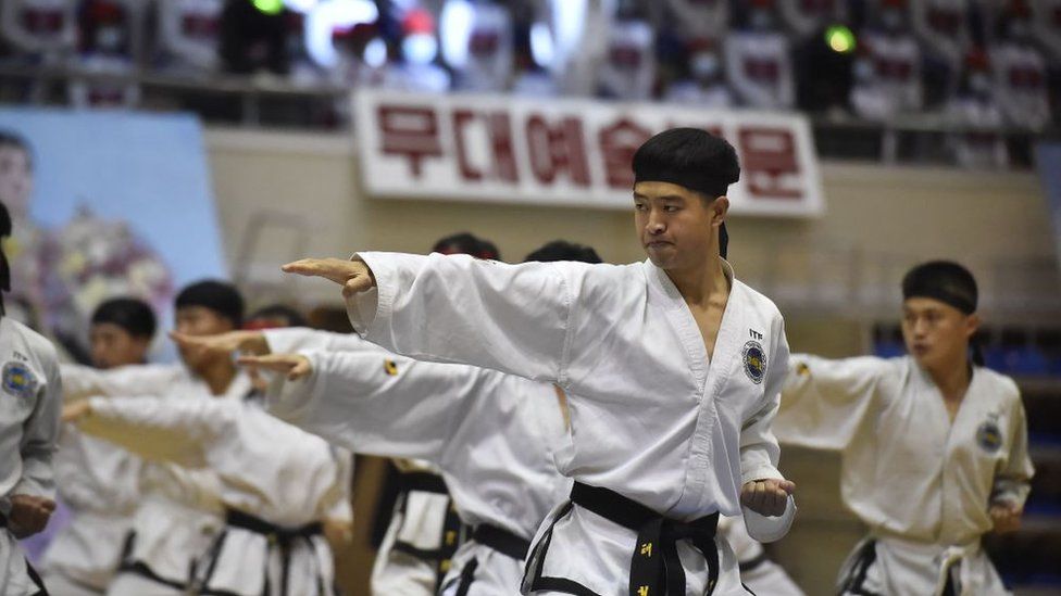 In this photo taken on November 29, 2022, participants take part in a taekwondo demonstration during the 52nd Sports Contest of Artists at the Basketball Gymnasium in Chongchun Street in Pyongyang.