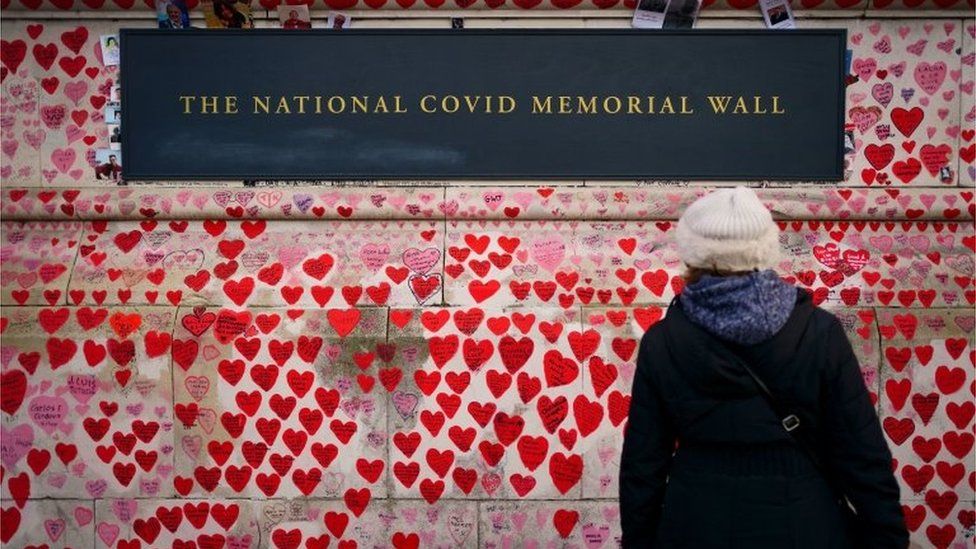 A person looks at National Covid Memorial Wall