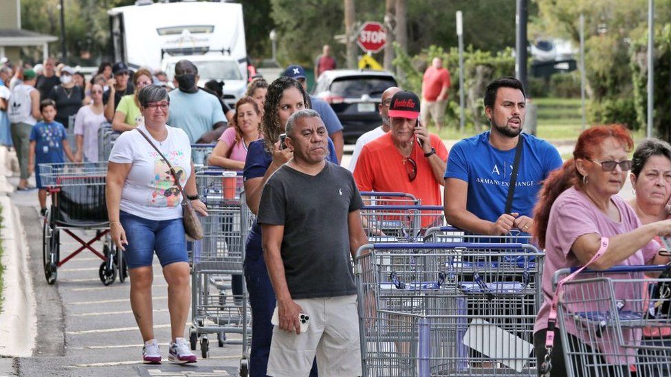 Shoppers wait in line at a grocery store in Kissimmee