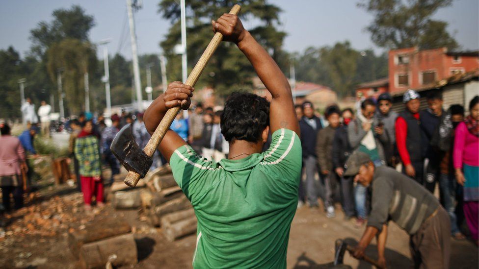 A Nepalese worker chops firewood sold by the government in Kathmandu, Nepal, 15 November 2015.