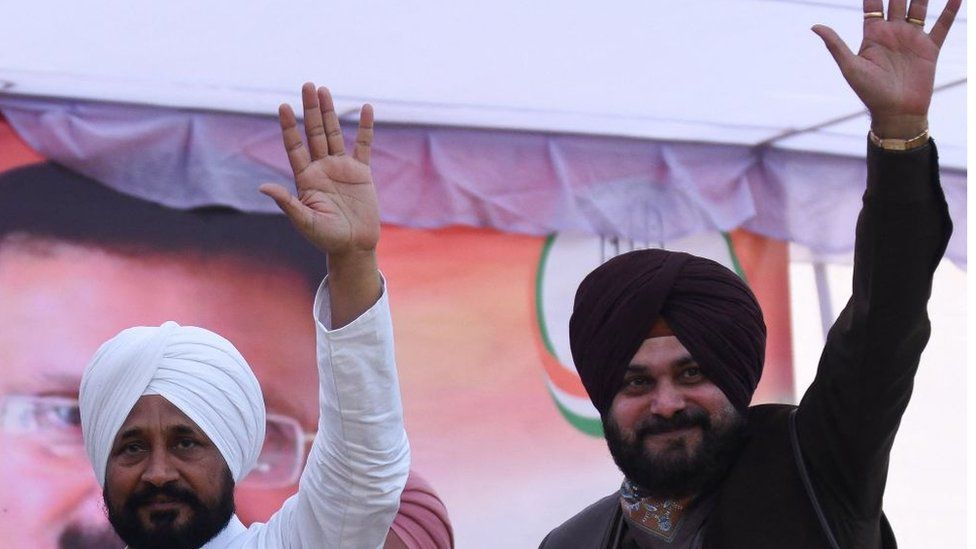 Punjab Congress president Navjot Singh Sidhu (R) with Punjab chief minister Charanjit Singh Channi waves towards the supporters during a rally ahead of the Punjab legislative assembly elections, in Amritsar on December 6, 2021.