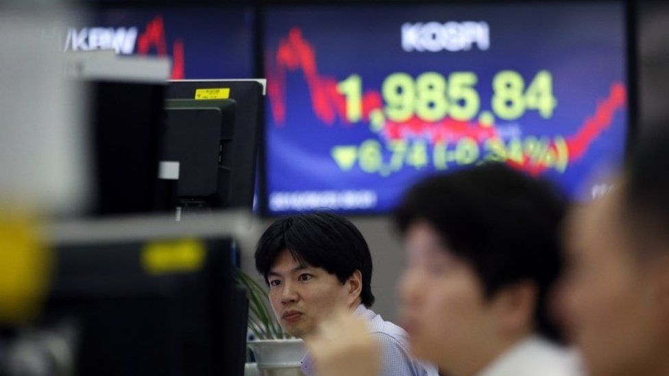 Currency traders watch computer monitors near the screen showing the Korea Composite Stock Price Index (KOSPI) at the foreign exchange dealing room in Seoul, South Korea, Thursday, June 23, 2016.
