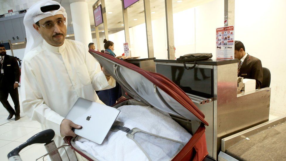 Kuwaiti social media activist Thamer al-Dakheel Bourashed puts his laptop inside his suitcase at Kuwait International Airport in Kuwait City before boarding a flight to the US