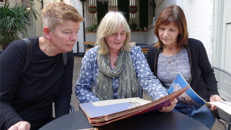 Chris, Leah and Gill look at their 1971 scrapbooks