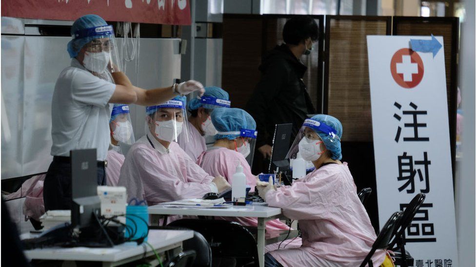 Staff in PPE waiting for people to get their inoculation at a popup walk-in COVID-19 vaccination center in Taipei Main station in Taipei, Taiwan, December 10, 2021.