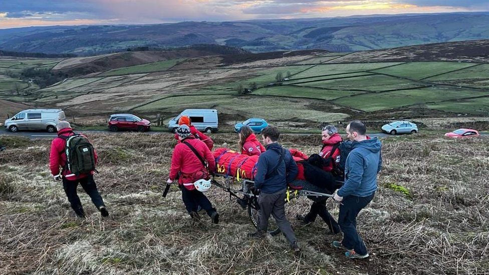 Members of the Edale Mountain Rescue Team help a paraglider