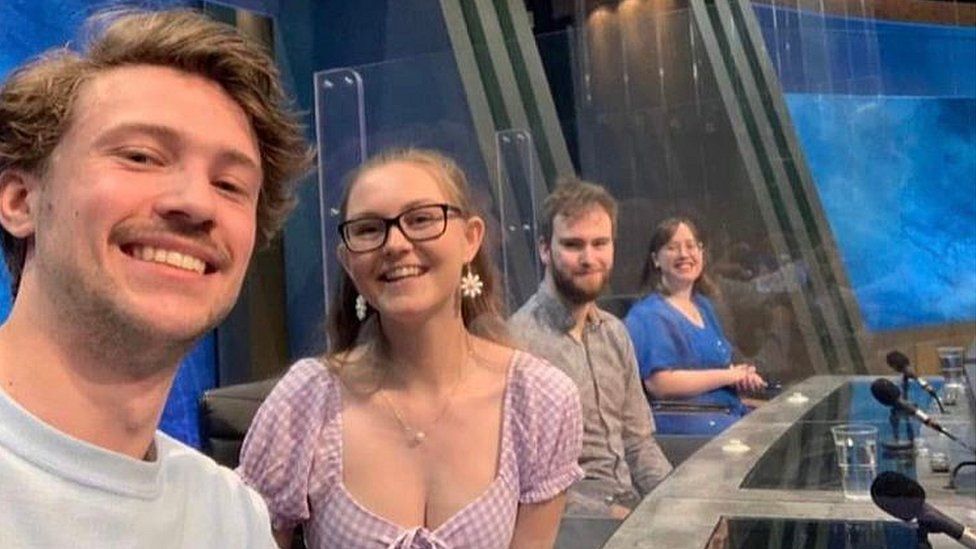 The four students smile as a selfie is taken in the studio