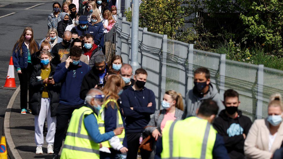 People line up outside a mobile vaccination centre, amid the outbreak of the coronavirus disease (COVID-19) in Bolton