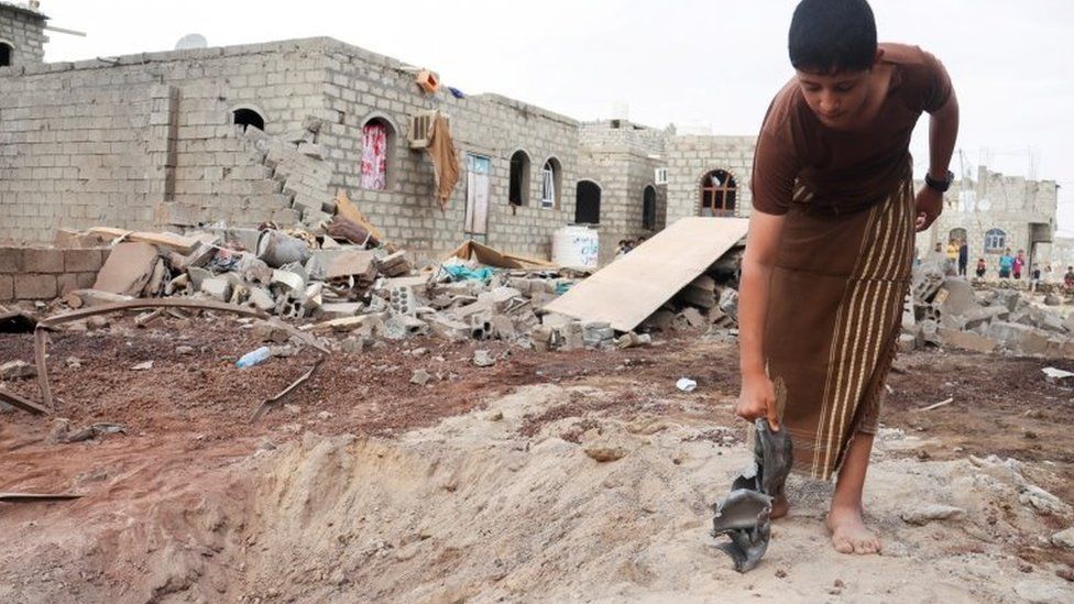 A boy holds shrapnel from a missile fired by Houthi fighters, in Marib, Yemen (3 October 2021)