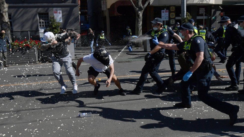 Protesters are pepper sprayed by police during an anti-lockdown protest in the central business district of Melbourne, Australia, 21 August 2021