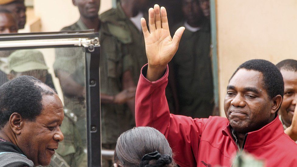 Zambian opposition leader Hakainde Hichilema waves to supporters from a police van as he leaves a courtroom in Lusaka on April 18, 2017. Hichilema"s arrest on treason charges - after his convoy allegedly refused to give way to the president"s motorcade on a main road in the west of the country - has fanned political tensions in Zambia
