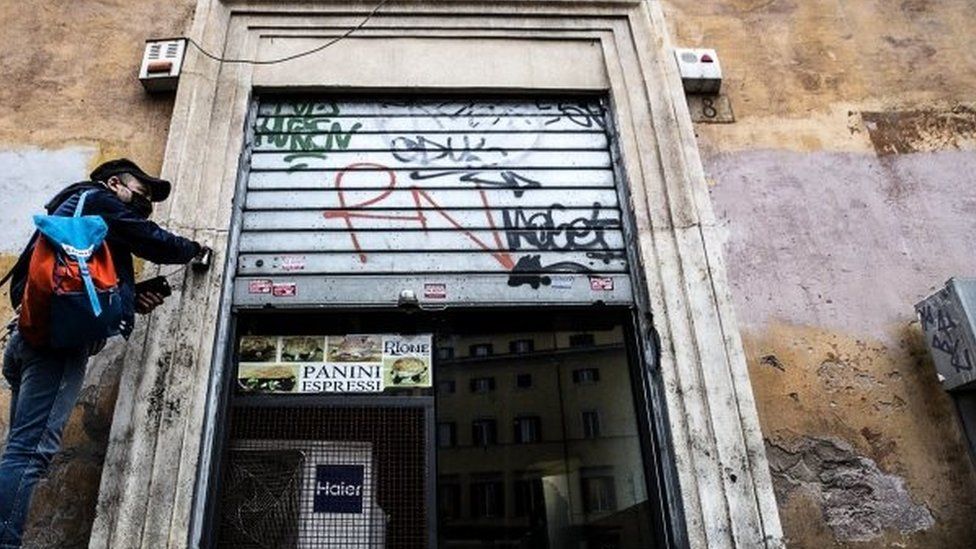 A man closes a sandwich bar in Rome, Italy. Photo: 12 March 2021