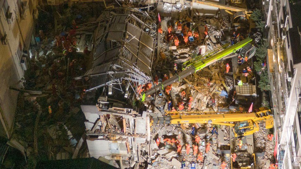 Aerial view of rescuers searching for trapped people in the debris of a collapsed hotel on July 13, 2021 in Suzhou