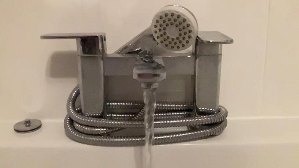 A bathroom tap and shower head