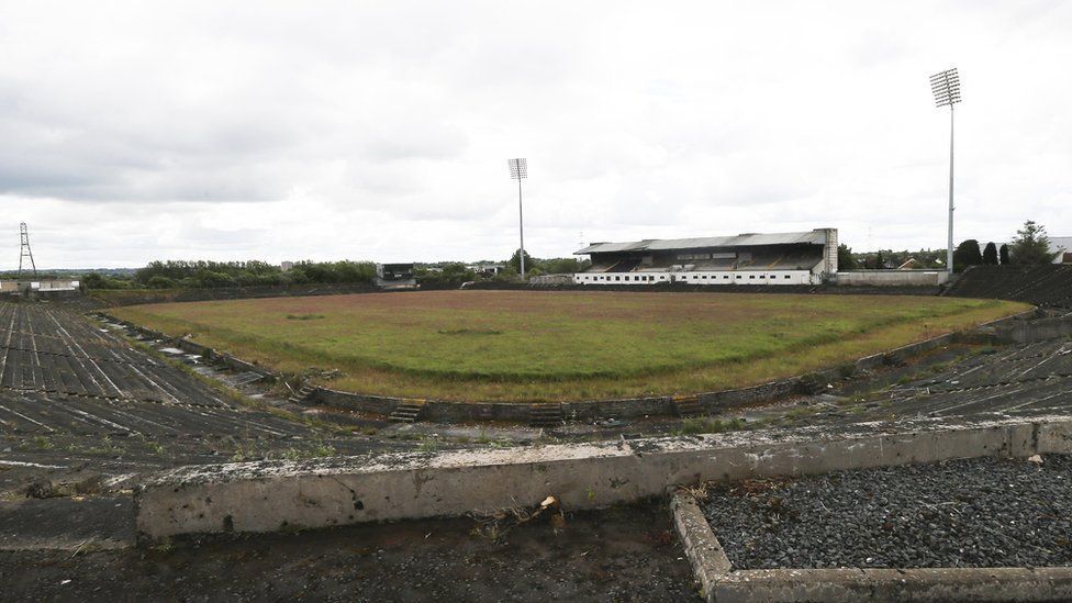 Broken terracing and an overgrown pitch at derelict stadium Casement Park