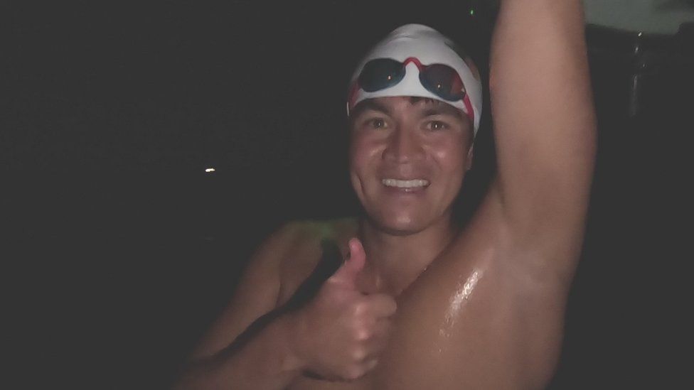 Andy Donaldson celebrates completing his latest swim