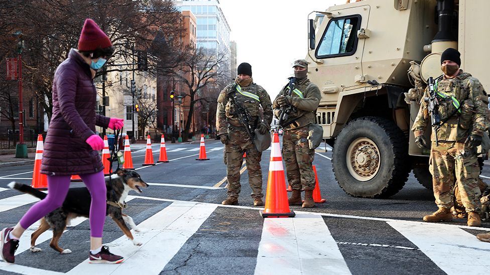 Человек переходит улицу на блокпосту, охраняемом сотрудниками Национальной гвардии в Вашингтоне, округ Колумбия - 16 января 2021 г.