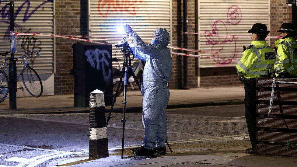 A forensics officer works at the scene of the shooting
