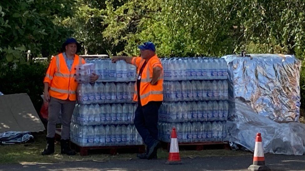 Workers standing with bottles of water