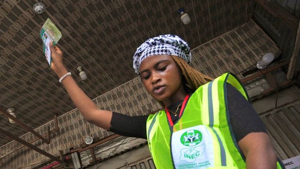 A woman holding up a ballot