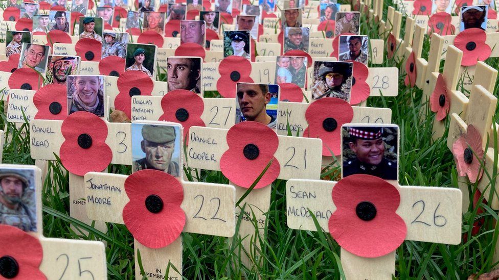 Poppies and crosses with photos in a field of remembrance