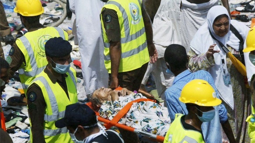 Members of the Saudi emergency services help carry an injured lady on a stretcher