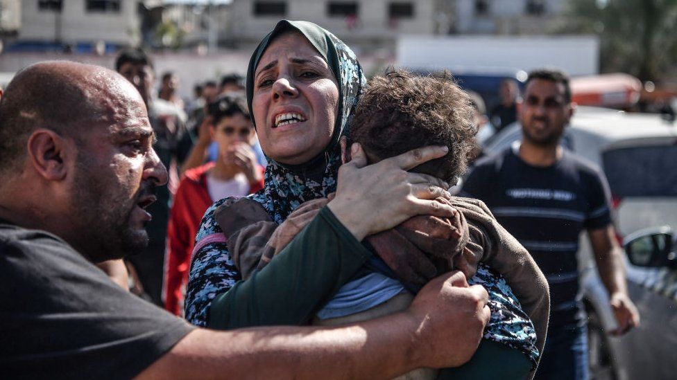 A man and woman console a child in the Gaza Strip