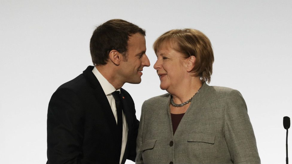 German Chancellor Angela Merkel kisses France's President Emmanuel Macron at the end of a press conference on 13 December 2017