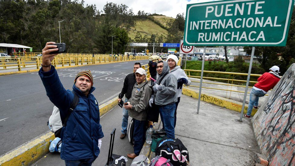 Venezuelans pose for a picture at the Rumichaca international bridge before crossing from Ipiales in Colombia, to Tulcan in Ecuador, on August 20, 2018
