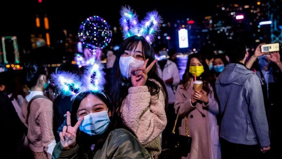 Women celebrate New Year's Eve with light-up bunny ears and festive lights