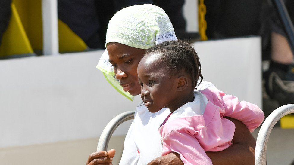 Mother and child from Africa disembarking in Italy