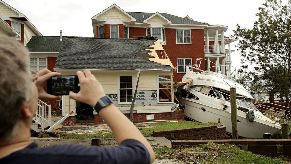 A boat is pictured crashed into a home in New Bern, North Carolina