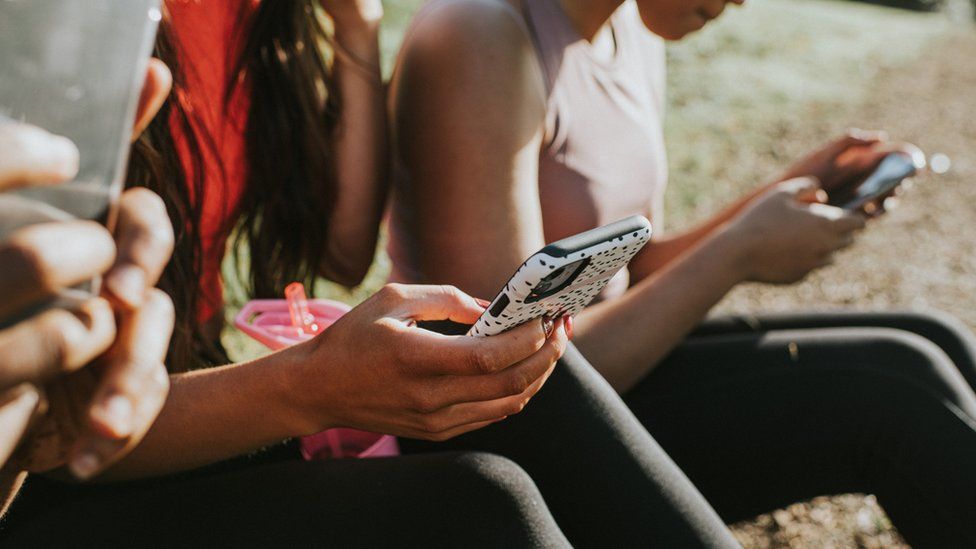 women holding their phones