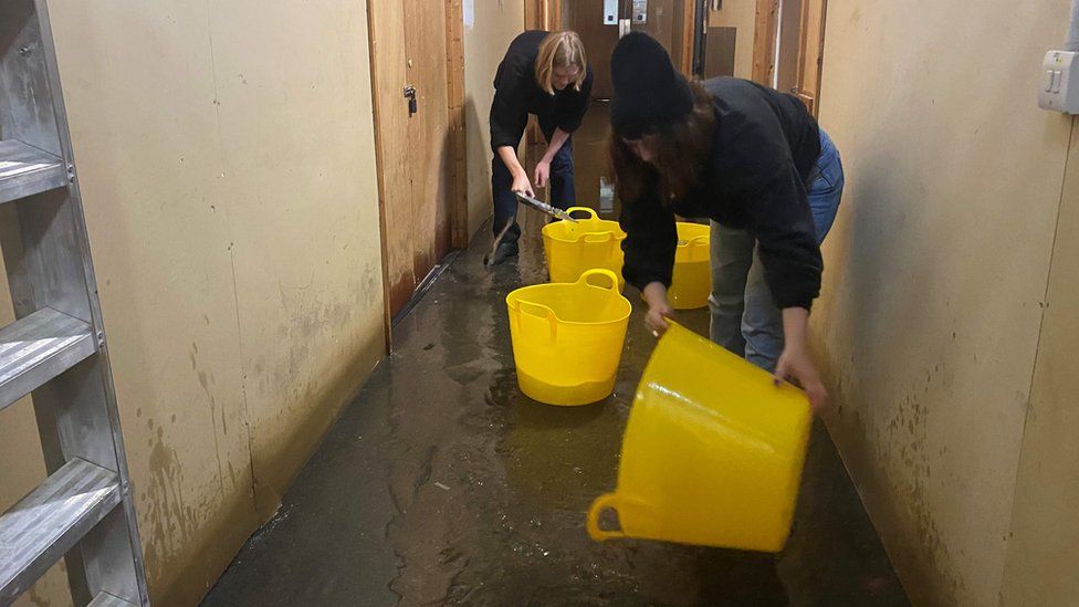 People at the London Centre for Book Arts scoop out the water on Friday morning
